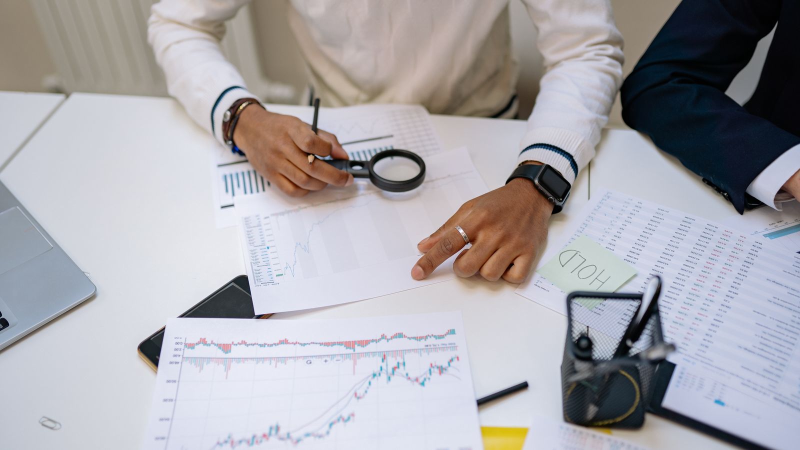 Analyst mit Kursgrafiken am Schreibtisch